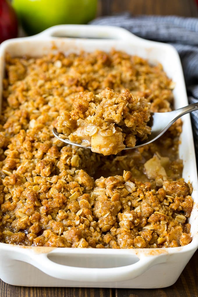 A spoon serving up a portion of apple crisp.