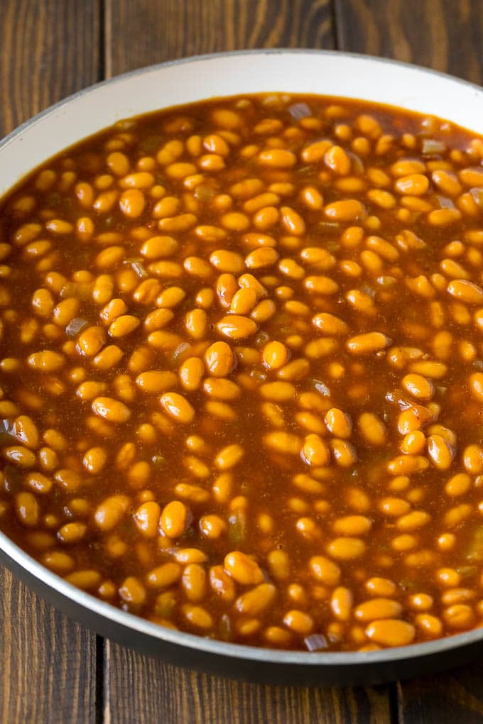 Beans mixed with sauce ingredients in a pan.