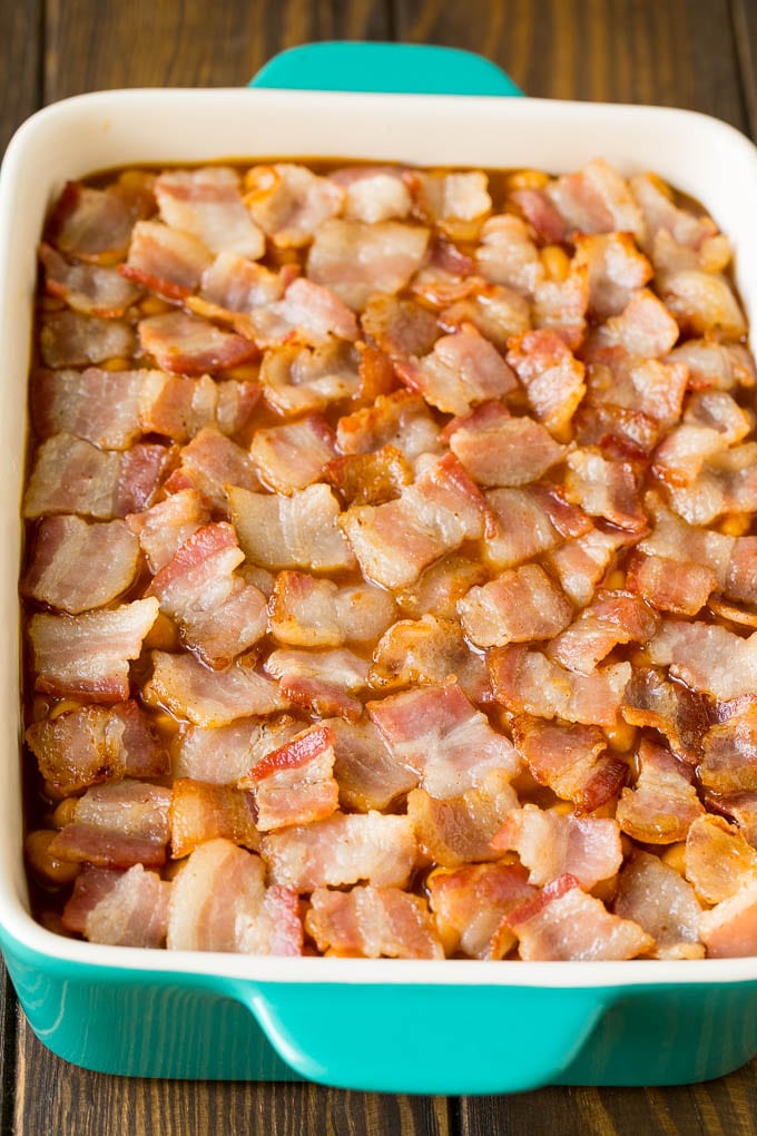 A baking dish of beans topped with chopped bacon.