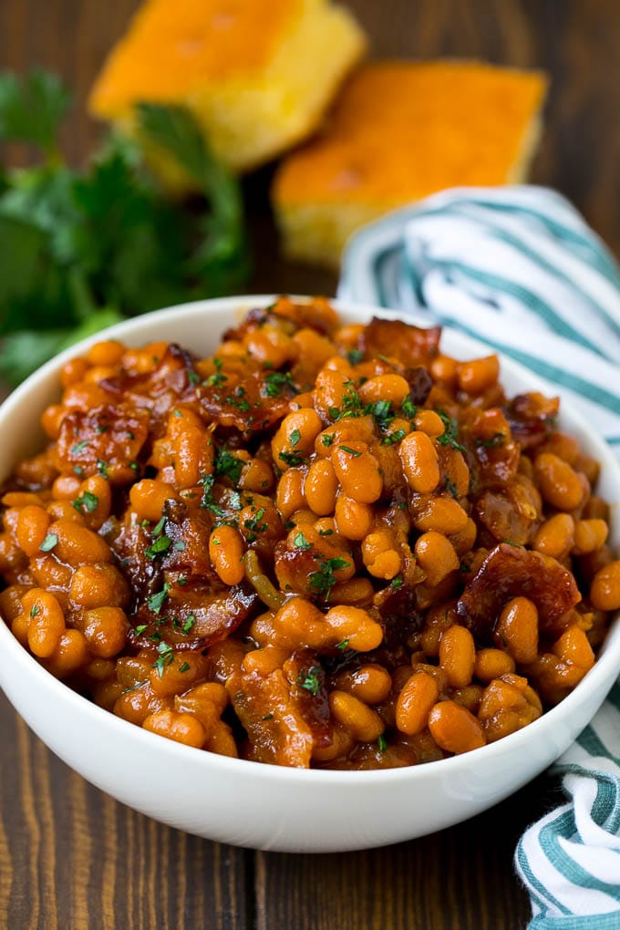 A bowl of baked beans made with bacon and brown sugar sauce.