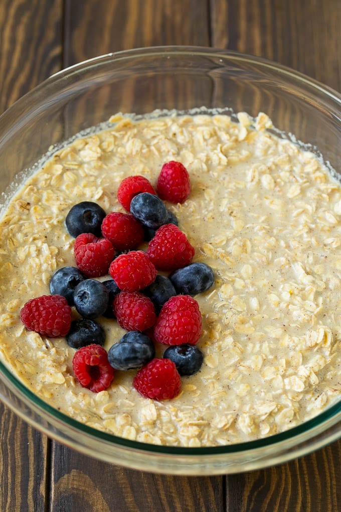 A bowl of oatmeal mixed with milk with fresh berries on top.
