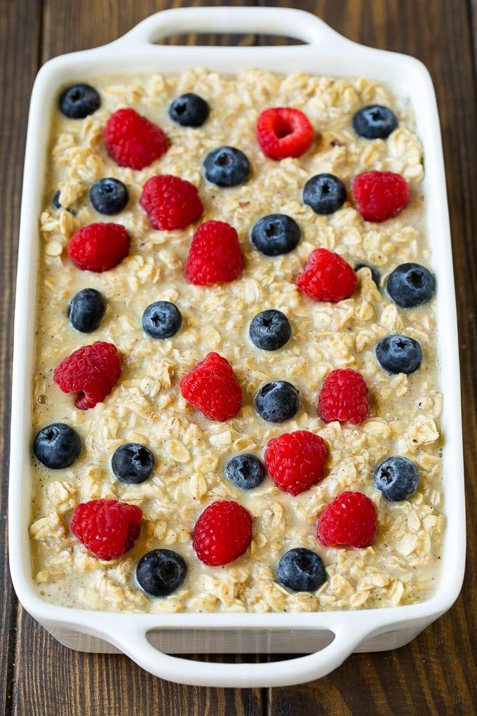 Oatmeal poured into a baking dish with berries on top.