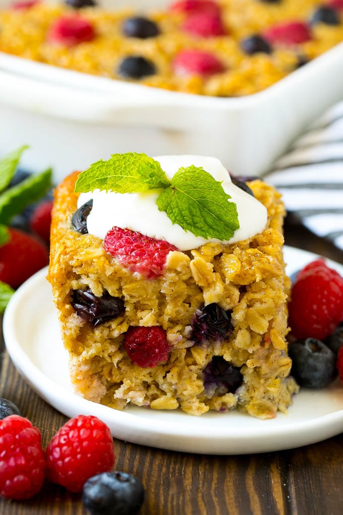 A serving of baked oatmeal topped with yogurt and served with fresh berries.