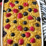 A dish of baked oatmeal with blueberries and raspberries on top.