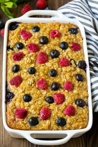 A dish of baked oatmeal with blueberries and raspberries on top.