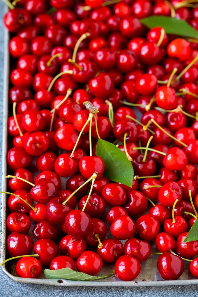 Fresh cherries spread out on a sheet pan.