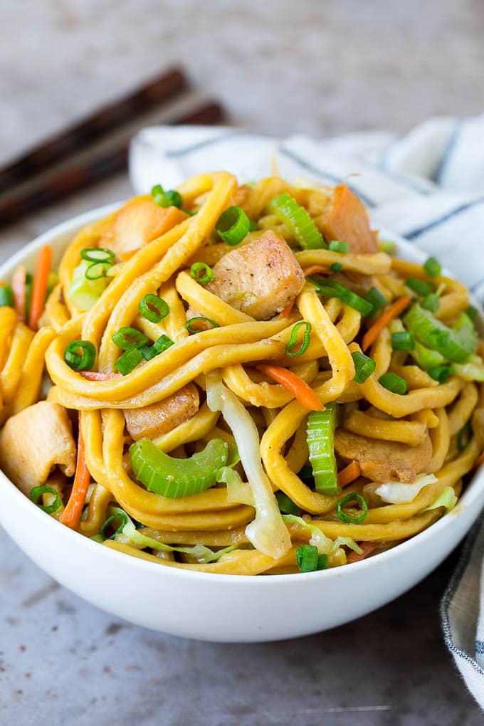 A bowl of chicken lo mein with noodles and vegetables.