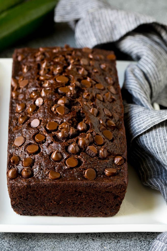 A loaf of chocolate zucchini bread with chocolate chips on top.