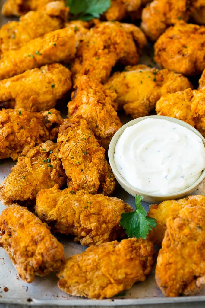 Fried chicken wings with parsley and a side of ranch dip.
