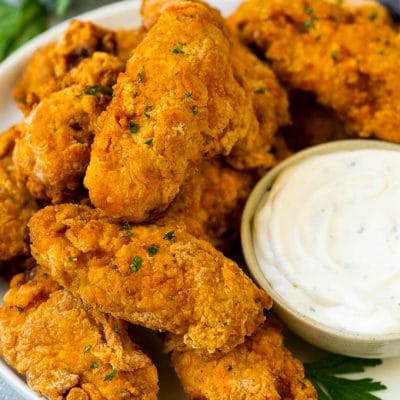 A plate of fried chicken wings served with ranch dip.