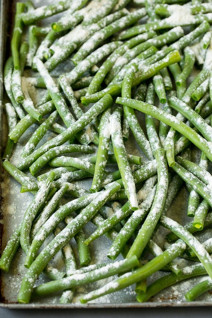 Green beans coated in flour on a pan.