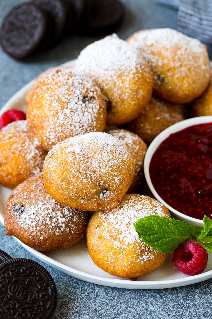 Fried Oreos topped with powdered sugar and served with raspberry sauce.