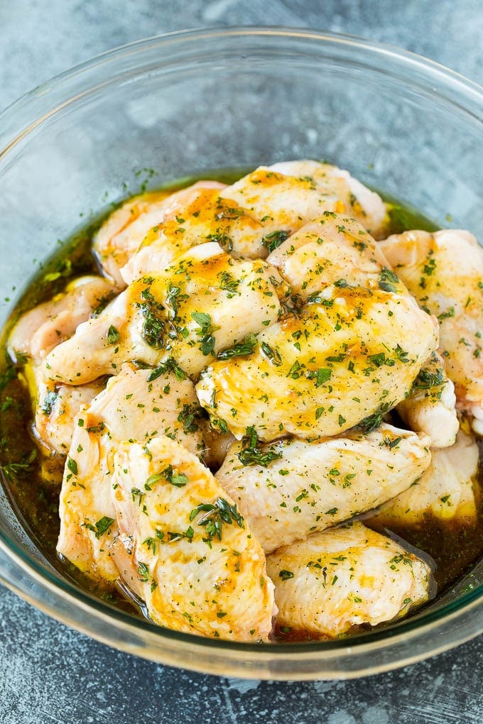 Chicken wings in a bowl of marinade.