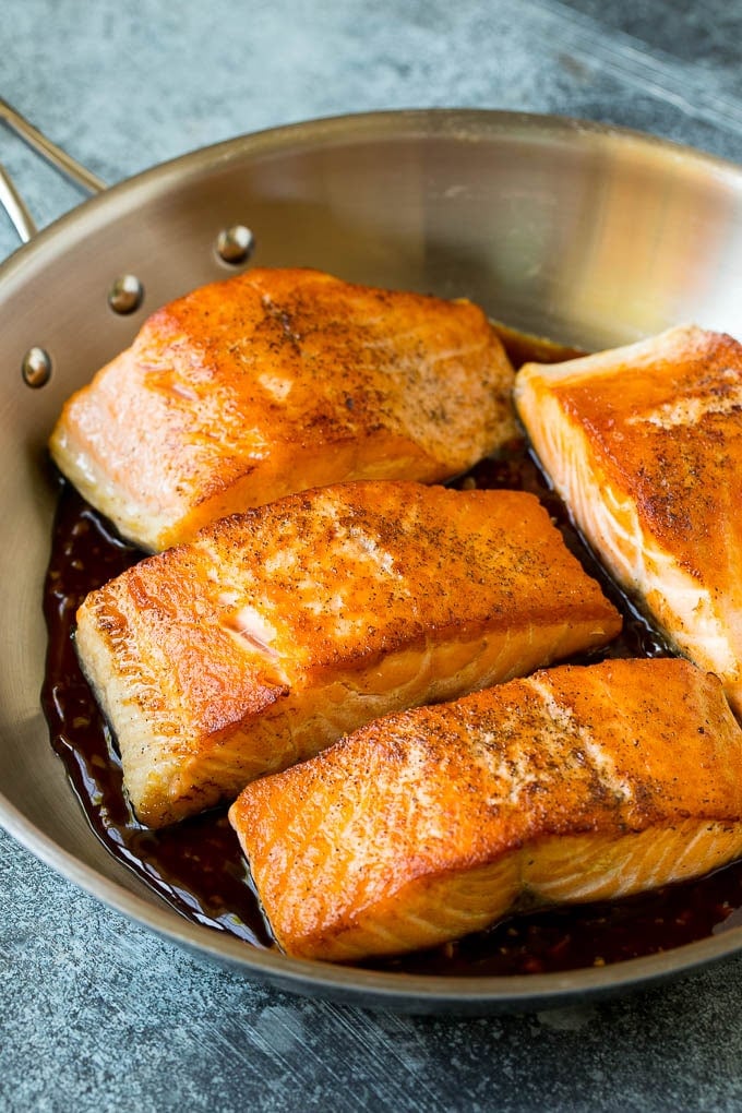 Salmon fillets sitting in honey glaze.