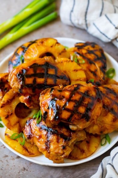 A plate full of huli huli chicken and grilled pineapple.