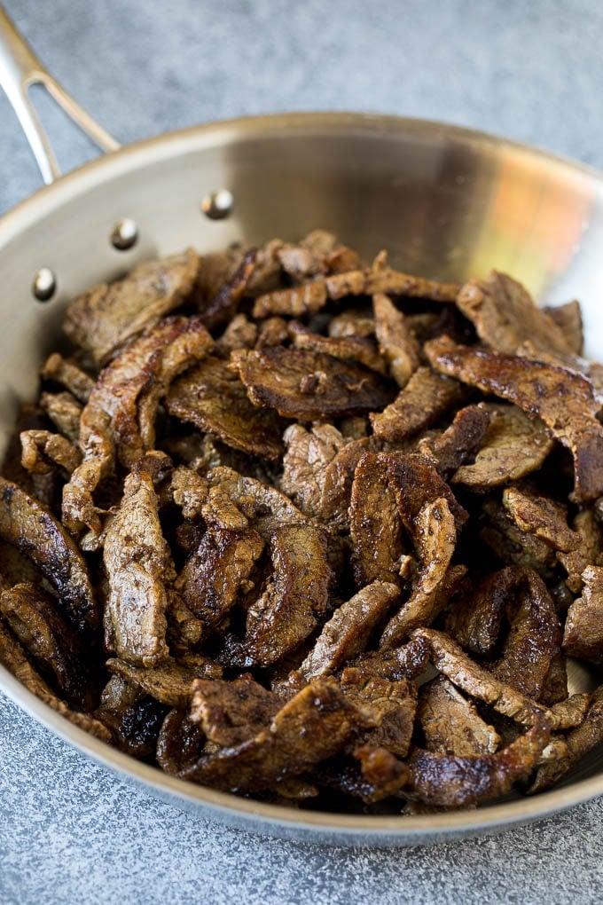 Thinly sliced steak in a pan.