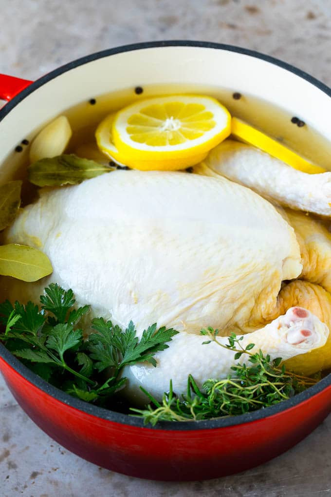 A whole chicken in a pot of brine.