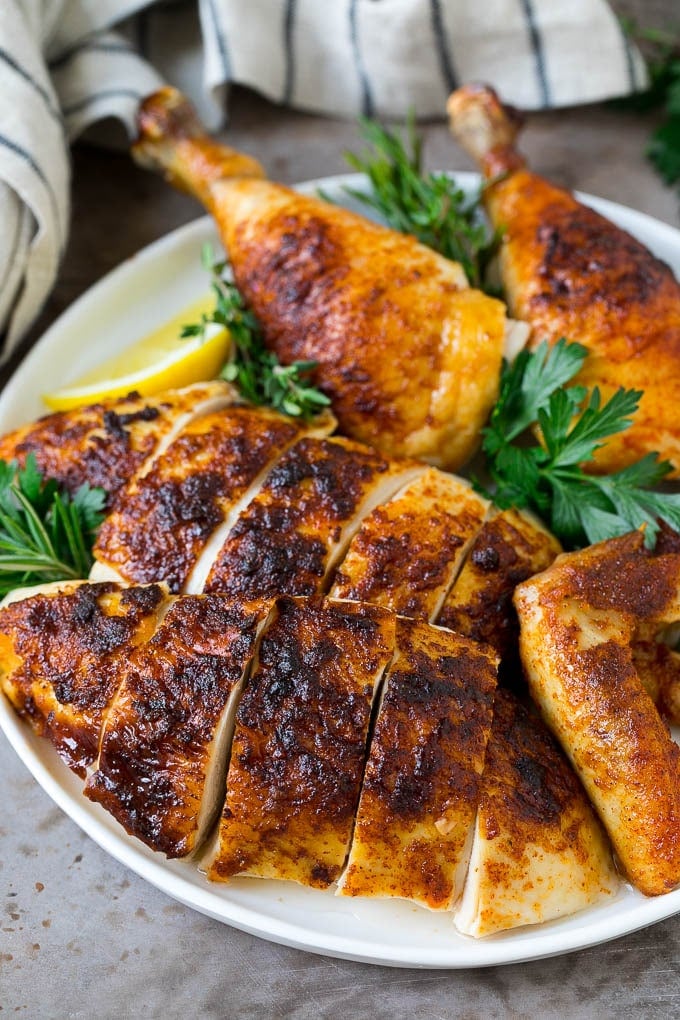 Sliced roasted chicken on a serving plate.