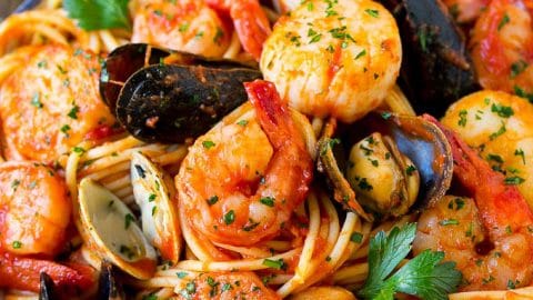 A bowl of seafood pasta with shrimp, clams and scallops.