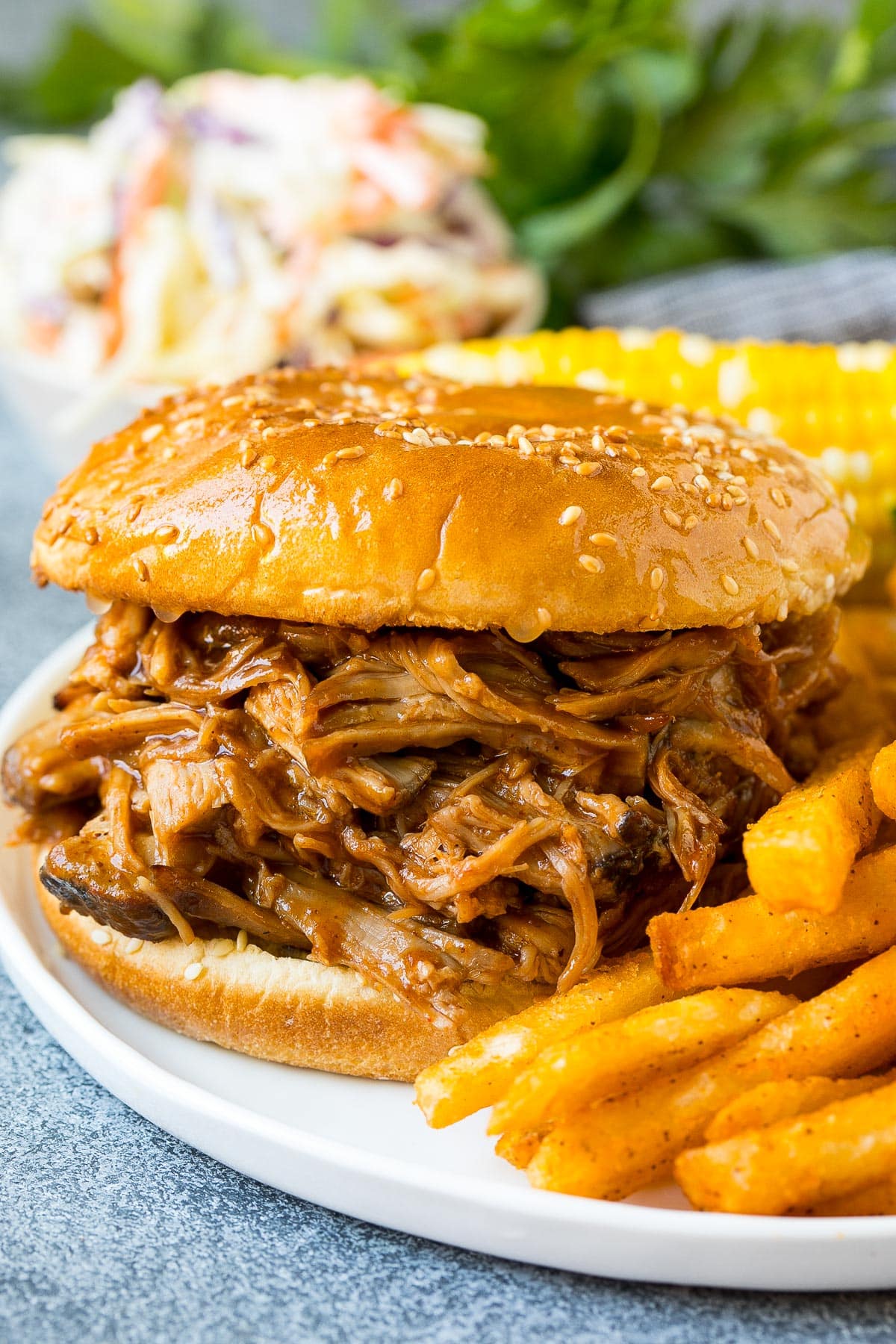A smoked pulled pork sandwich served with french fries.