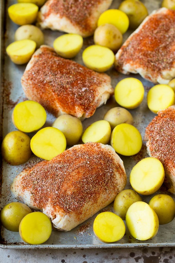 Chicken thighs coated in spices with small potatoes.