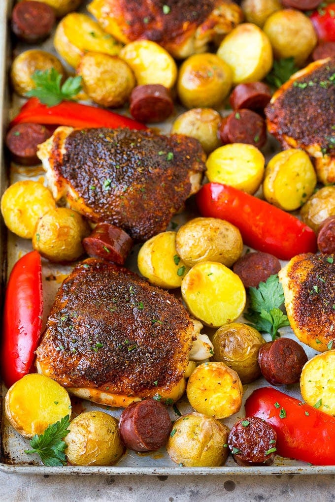 A sheet pan of Spanish chicken with potatoes, bell peppers and sausage.