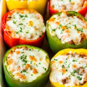 Stuffed bell peppers in a baking dish topped with melted cheese.