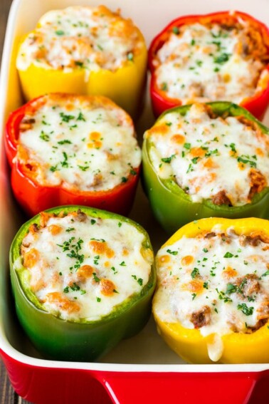 Stuffed bell peppers in a baking dish topped with melted cheese.
