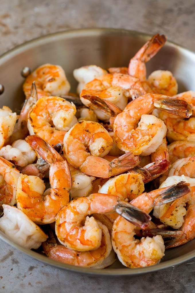 Sauteed jumbo shrimp in a skillet.