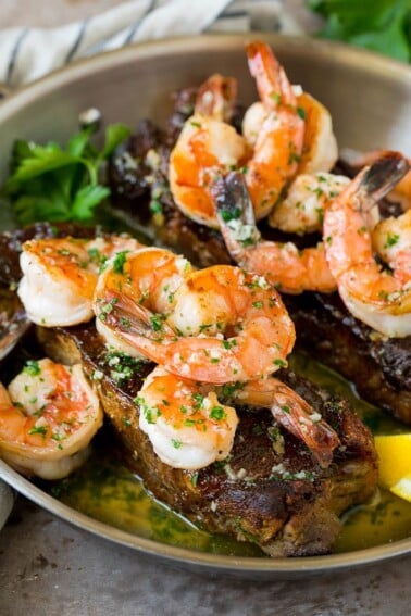 Surf and turf with seared strip steaks topped with jumbo shrimp.
