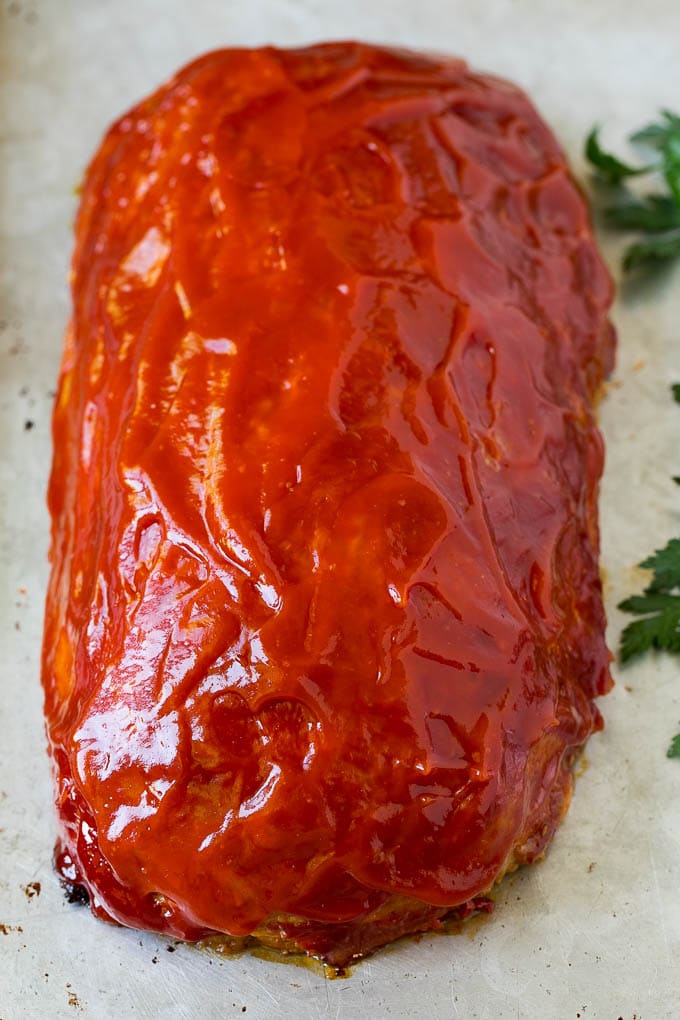 A baked meatloaf topped with ketchup.