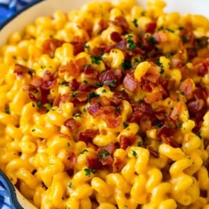 Bacon mac and cheese in a skillet, garnished with chopped parsley.