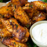 Baked chicken wings coated in spices and served with ranch dip.