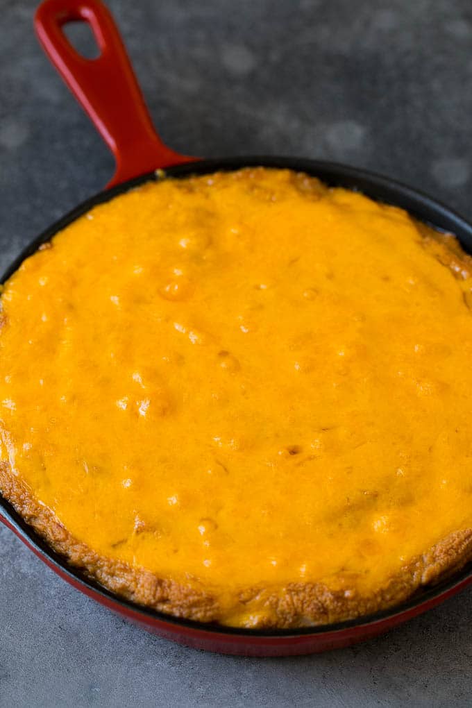 Baked refried beans topped with melted cheddar cheese.