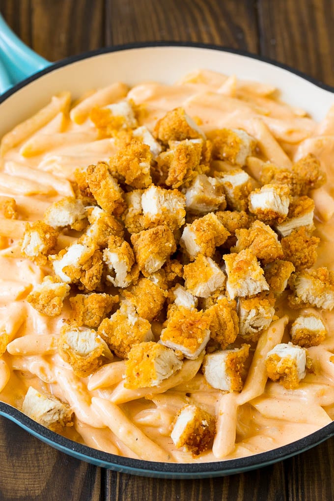 Chopped chicken tenders on top of cheesy pasta.