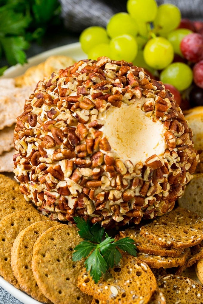 A cheese ball with a serving scooped out.