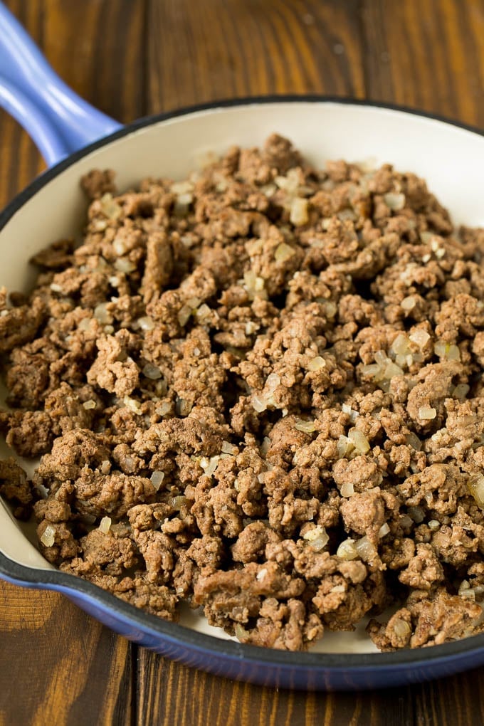 Ground beef with onions in a skillet.