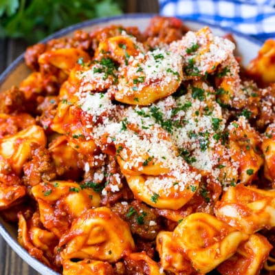 Cheese tortellini in homemade meat sauce, topped with parsley and parmesan cheese.