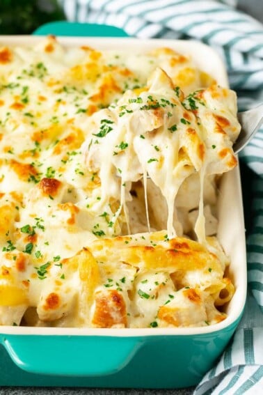 A spoon serving up a portion of chicken Alfredo bake.