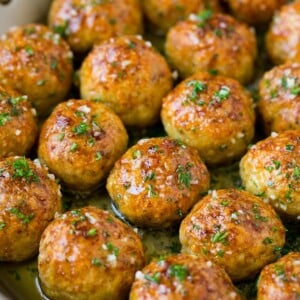 Chicken meatballs in a skillet of garlic butter.