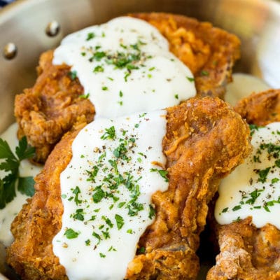 Fried pork chops topped with creamy gravy and parsley.