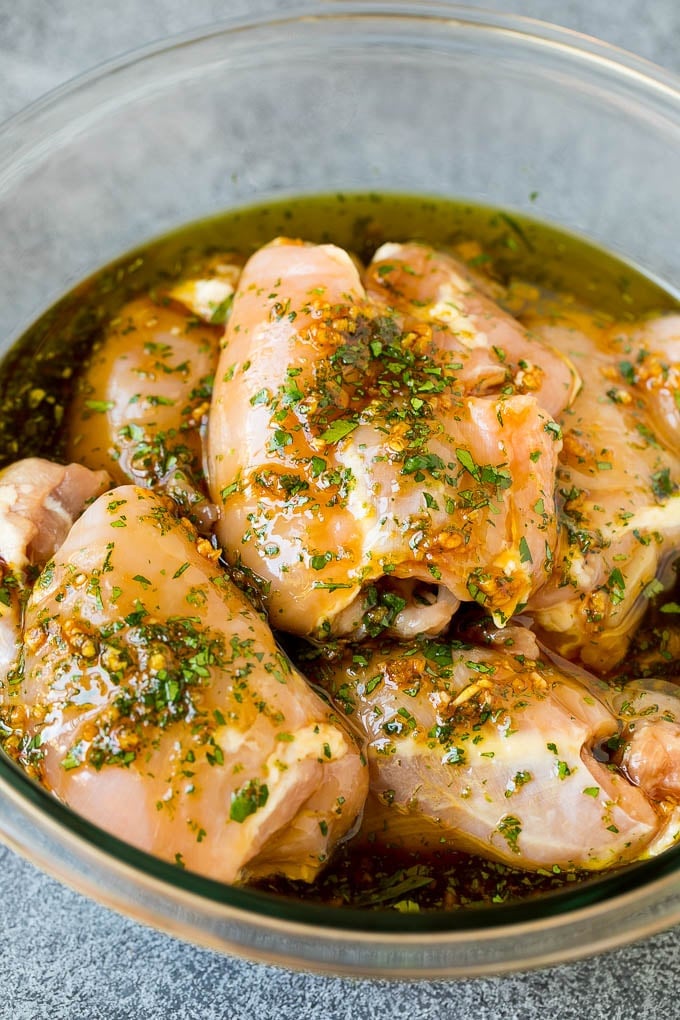 Chicken thighs in a bowl of marinade.