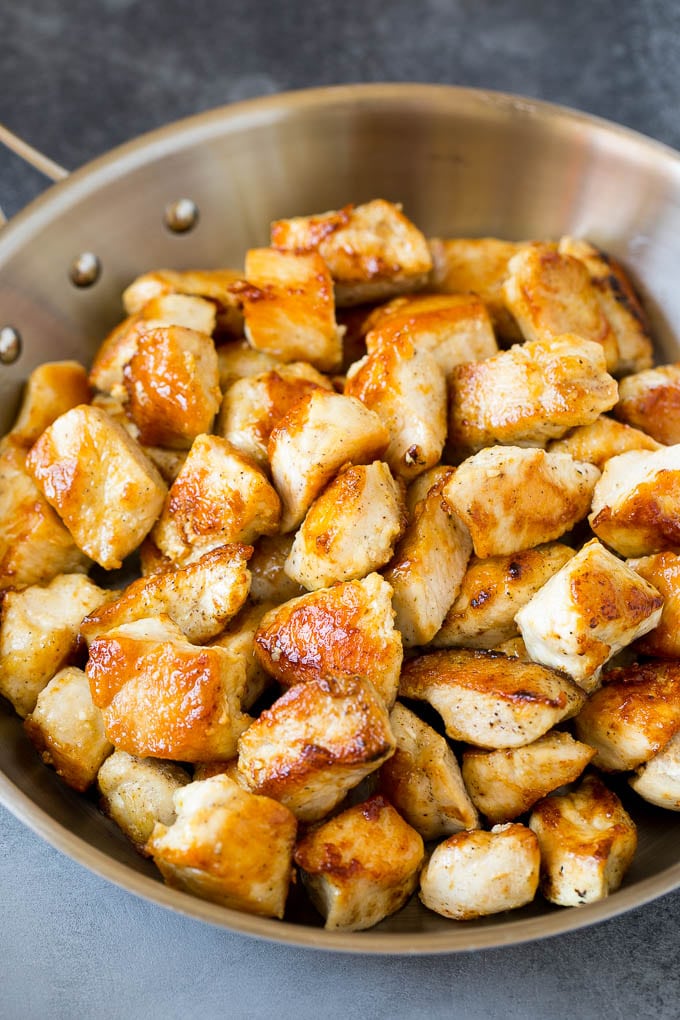 Seared chicken breast pieces in a pan.