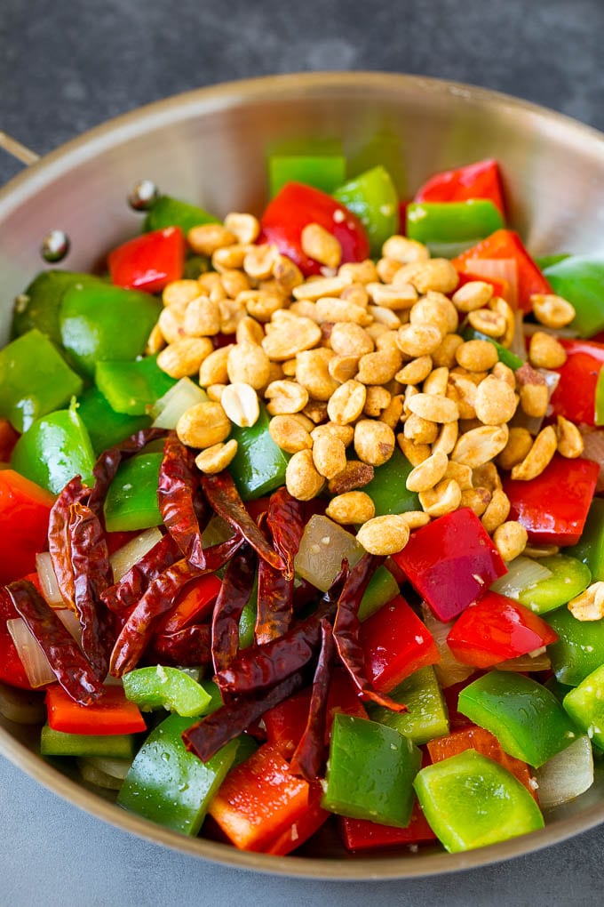 Bell peppers, peanuts and red chilies in a skillet.