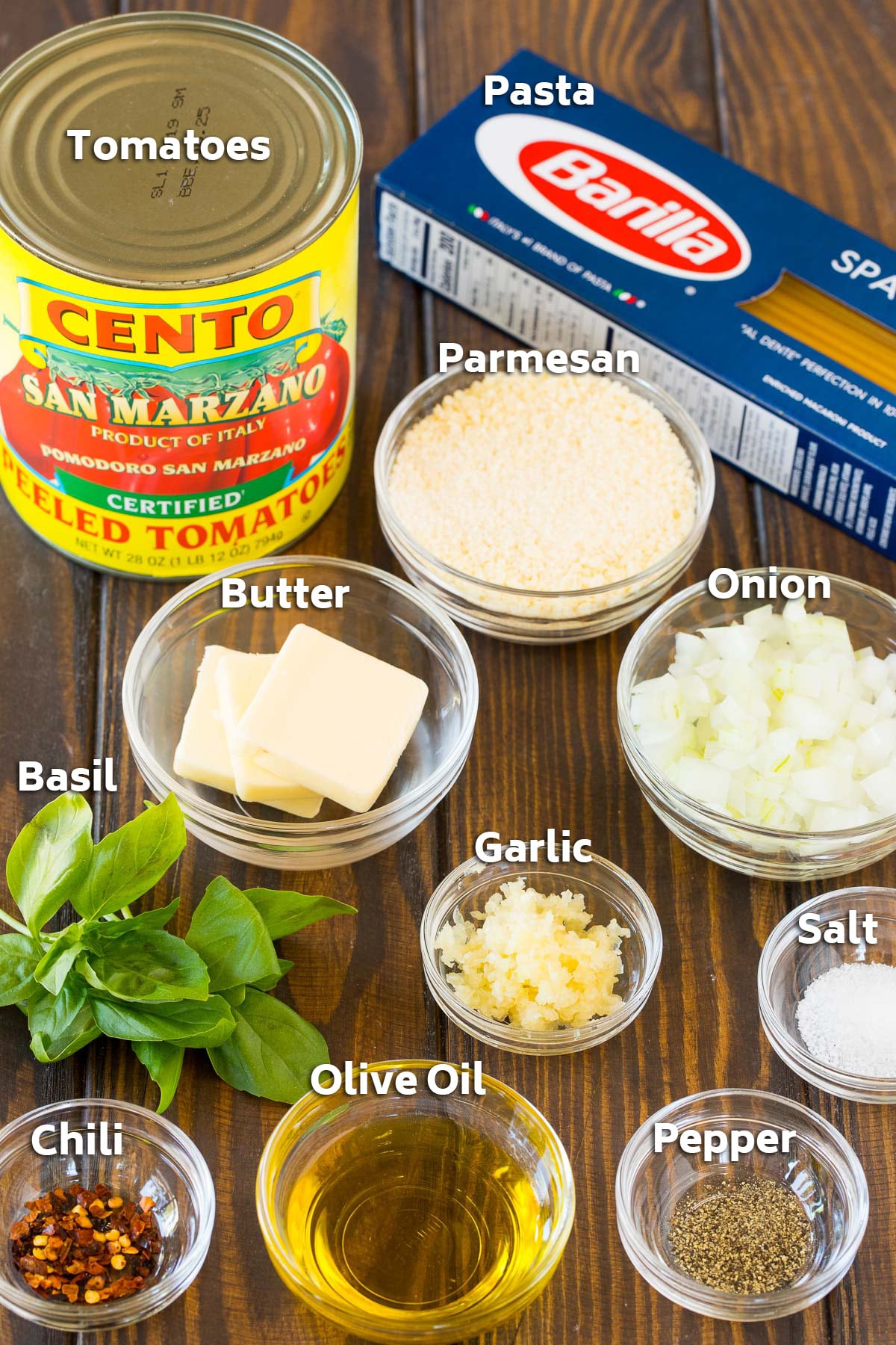 Bowls of ingredients including olive oil, vegetables and seasonings, and a box of pasta and can of tomatoes.