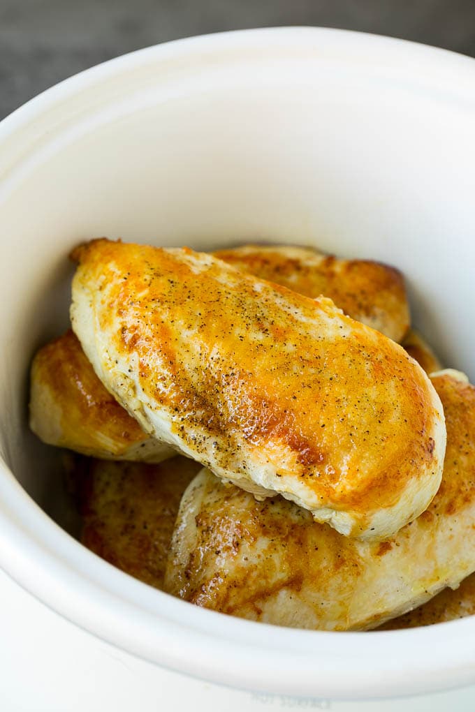Seared chicken breasts in a crock pot.