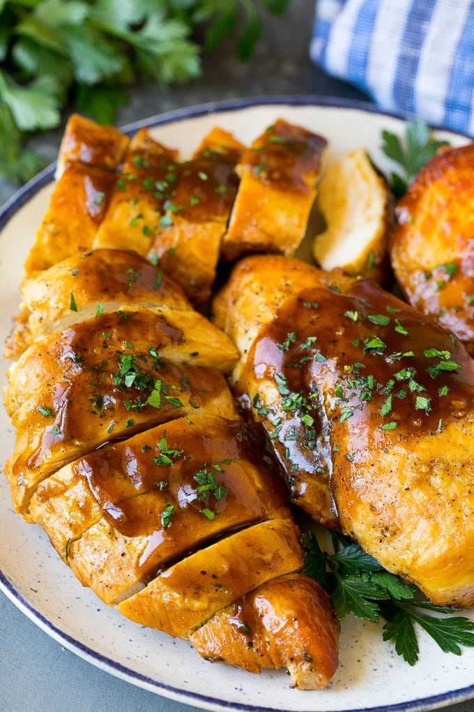 Sliced crock pot chicken breasts on a serving plate.