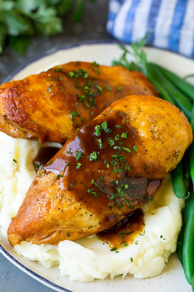 Slow cooker chicken breast served with mashed potatoes and green beans.