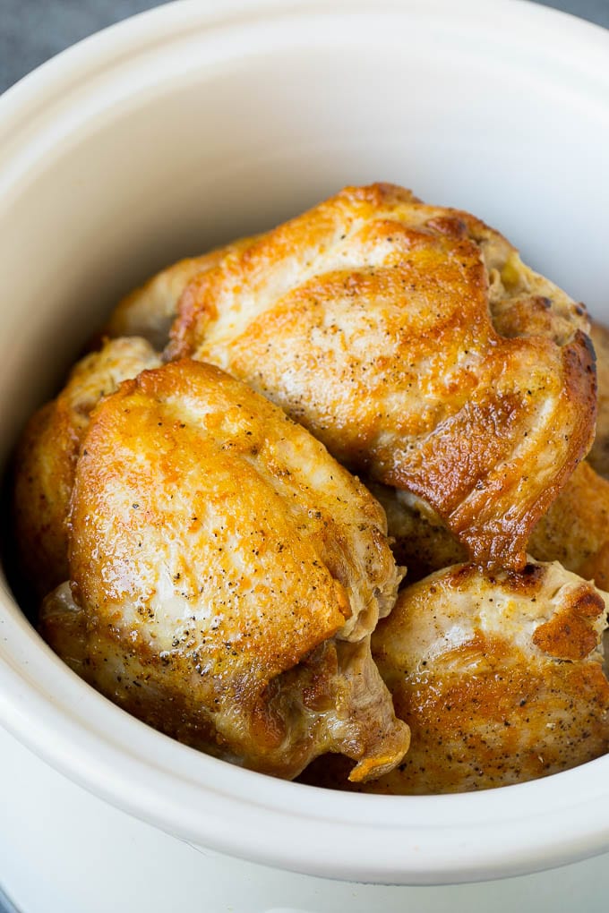 Seared chicken thighs in a crock pot.
