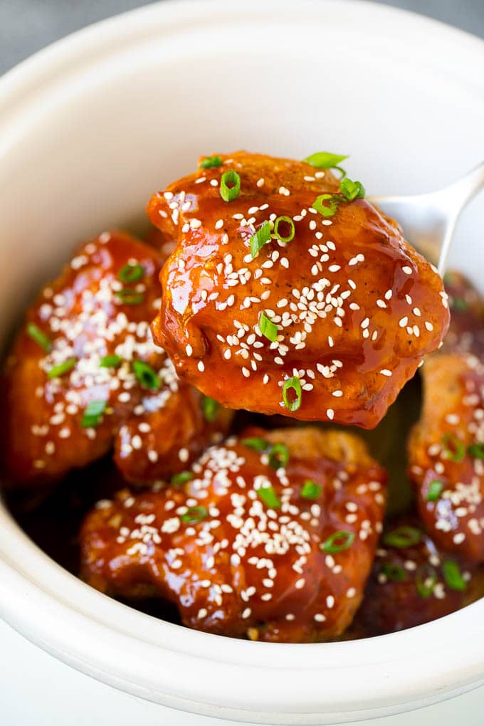 A spoon serving up a portion of honey garlic chicken.